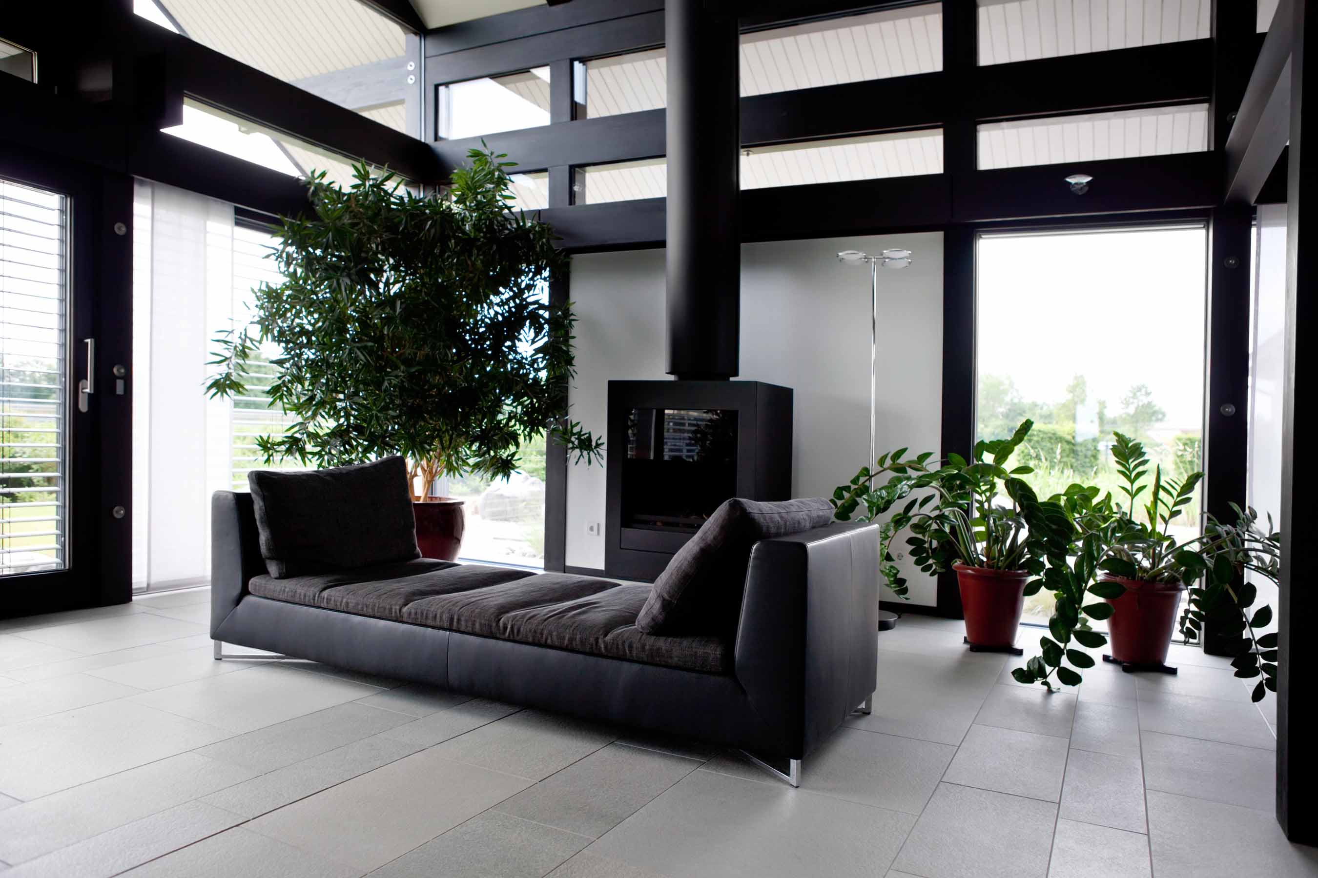 Salon contemporain avec poutres noires, murs clairs et grandes baies vitrées – peinture et décoration intérieure
